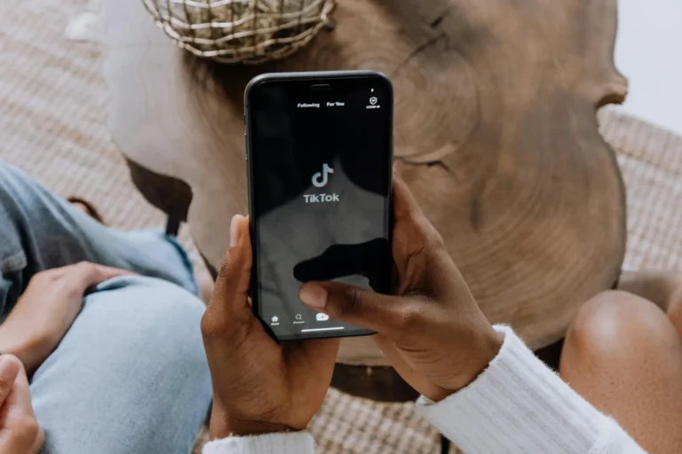 tangan memegang handphone dengan layar menunjukkan tiktok